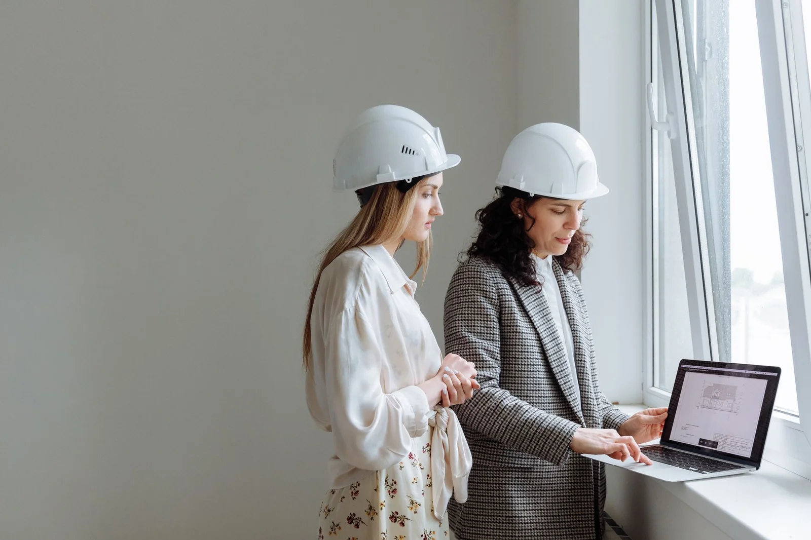 Architecte et thermicien comparant deux variantes de calcul sur un écran