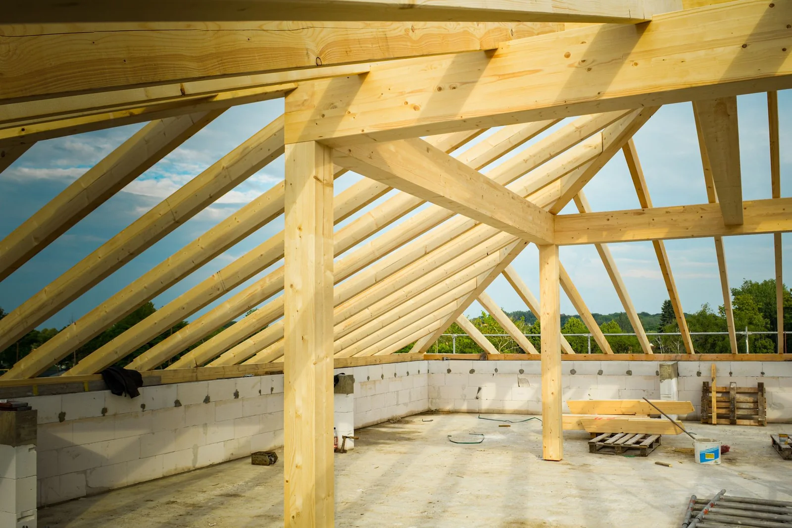 Poutres en bois et briques de réemploi triées sur une plateforme de chantier